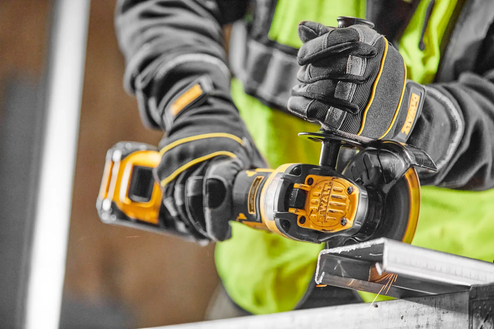 Persona con guanti tiene utensile cordless DEWALT XR FlexVolt in officina.