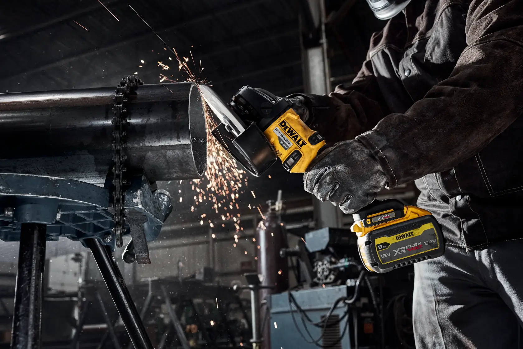 Persona usa mola a batteria DEWALT per tagliare tubo metallico, scintille in officina.