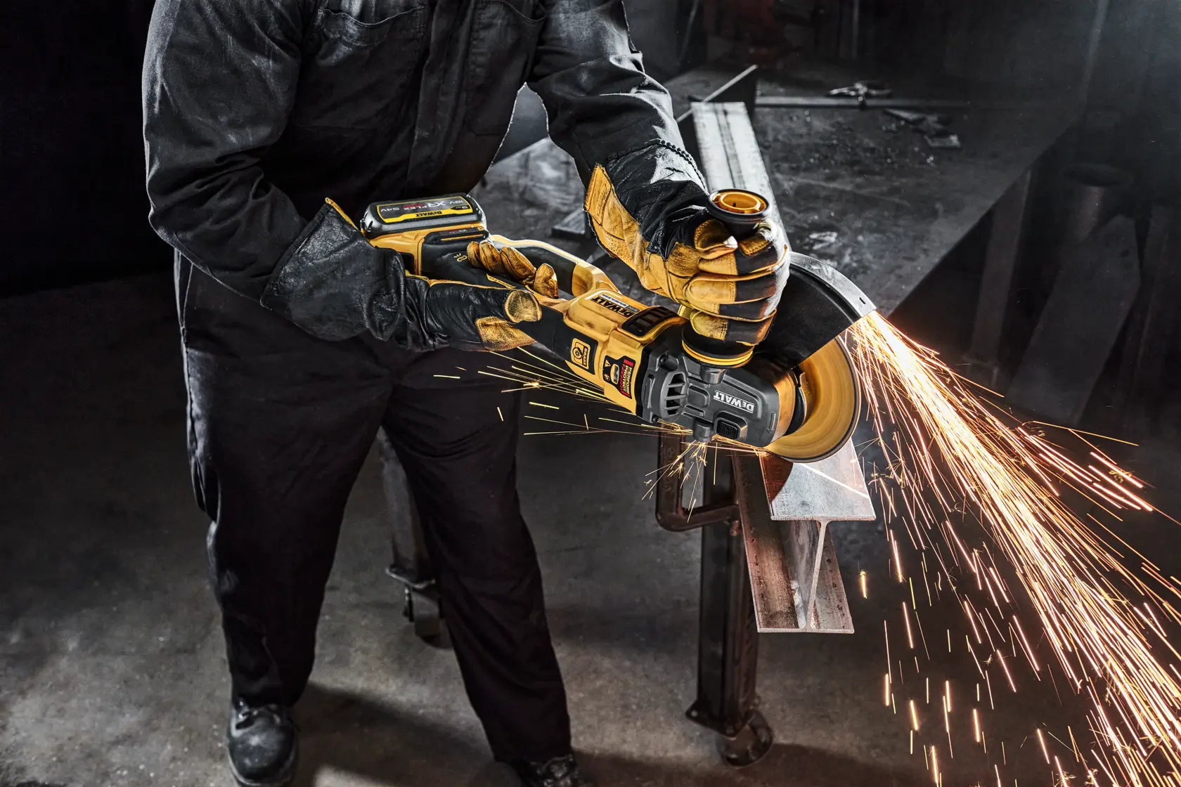 Persona usa smerigliatrice DEWALT senza fili, scintille mentre lavora il metallo in ambiente industriale.