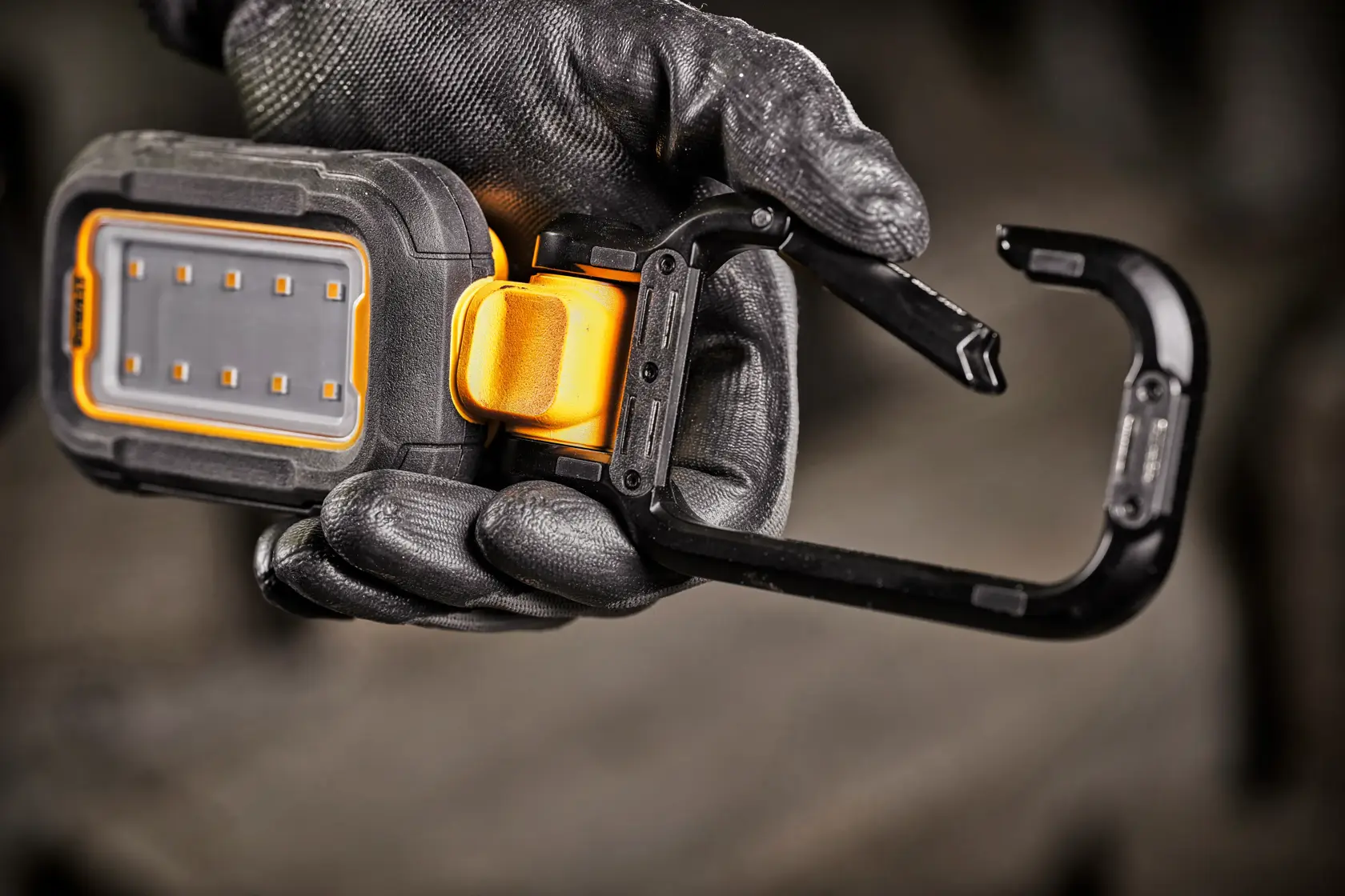 Lampe de travail LED portable DEWALT DCL182 avec un boîtier robuste noir et jaune, un support réglable et plusieurs ampoules LED, présentée sur fond blanc.
