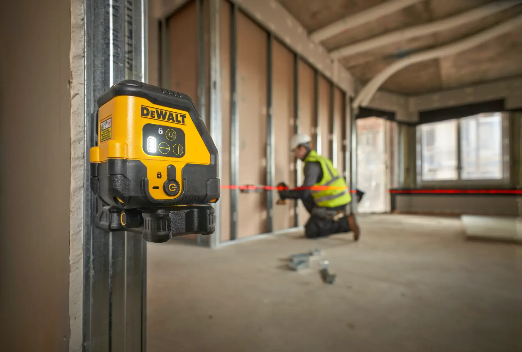 DEWALT laser level kit including a black and yellow laser level device, a sturdy carrying case with handle and DEWALT logo, a yellow USB-C charging cable, and a metal ruler.