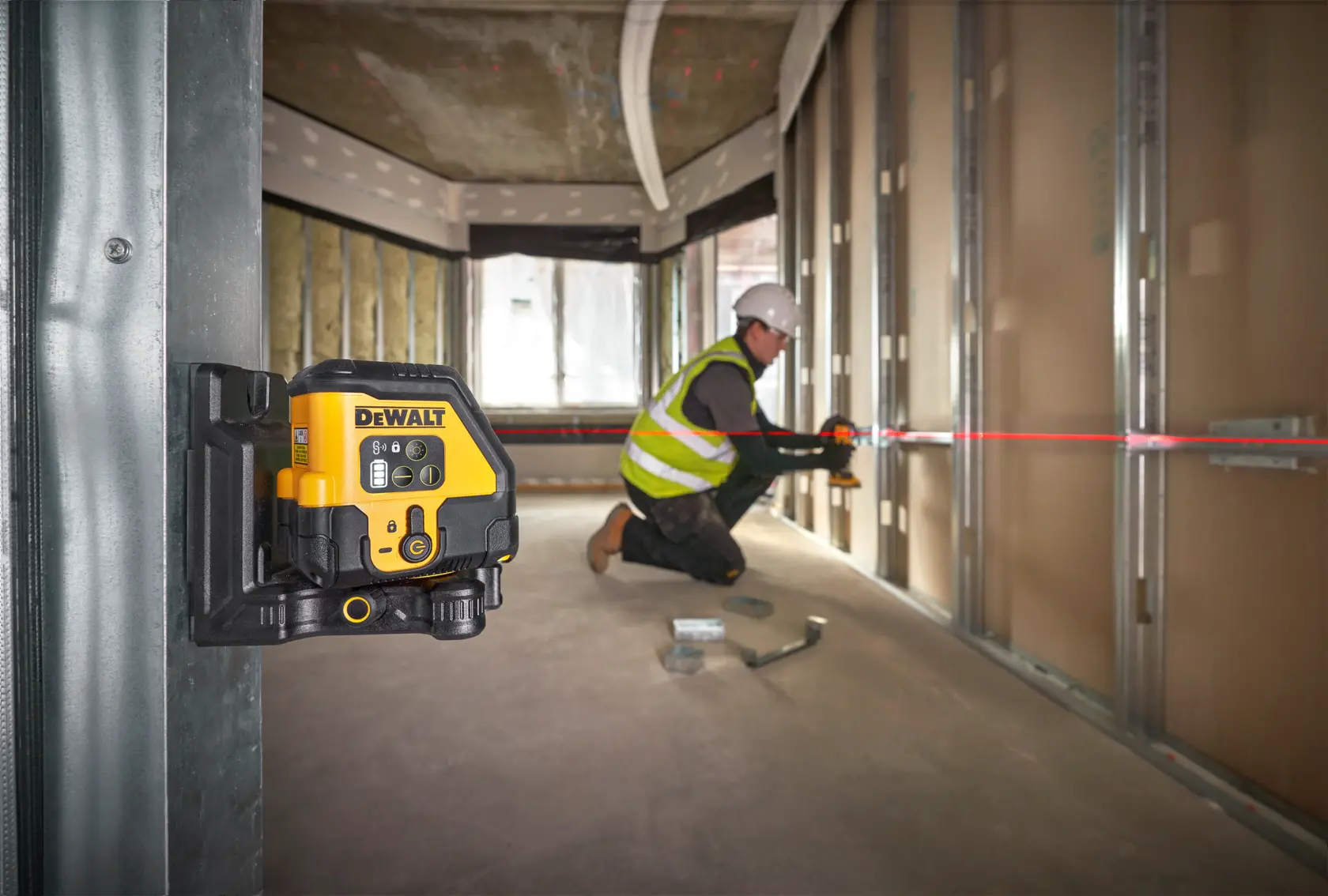 DEWALT laser level kit including a black and yellow laser level device, a sturdy carrying case with handle and DEWALT logo, a yellow USB-C charging cable, and a metal ruler.