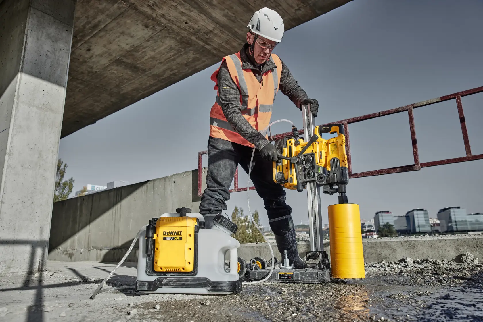 Close-up view of a DEWALT core drill model DCPS151 mounted on a vertical rail, highlighting its mirrored user controls and locking mechanism. Text overlay reads 'MIRRORED USER CONTROLS - LOCK THE CORE DRILL IN PLACE.'