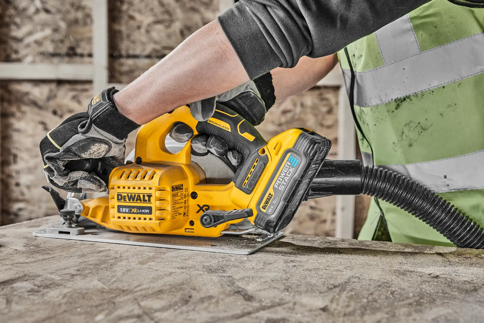 Persona usa una sega circolare DEWALT a batteria con aspirazione su una superficie di legno.