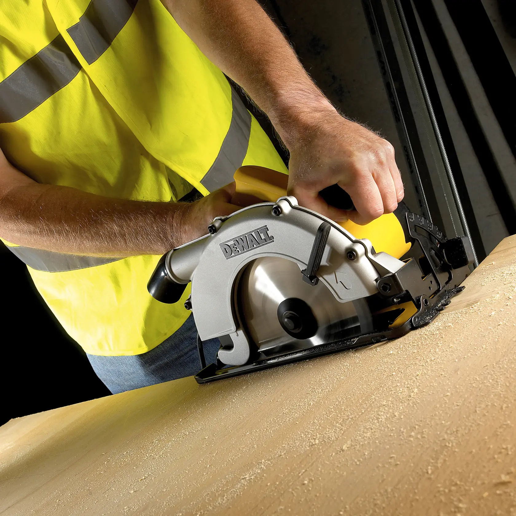 Persona taglia legno con sega circolare DEWALT, indossa un giubbotto giallo.