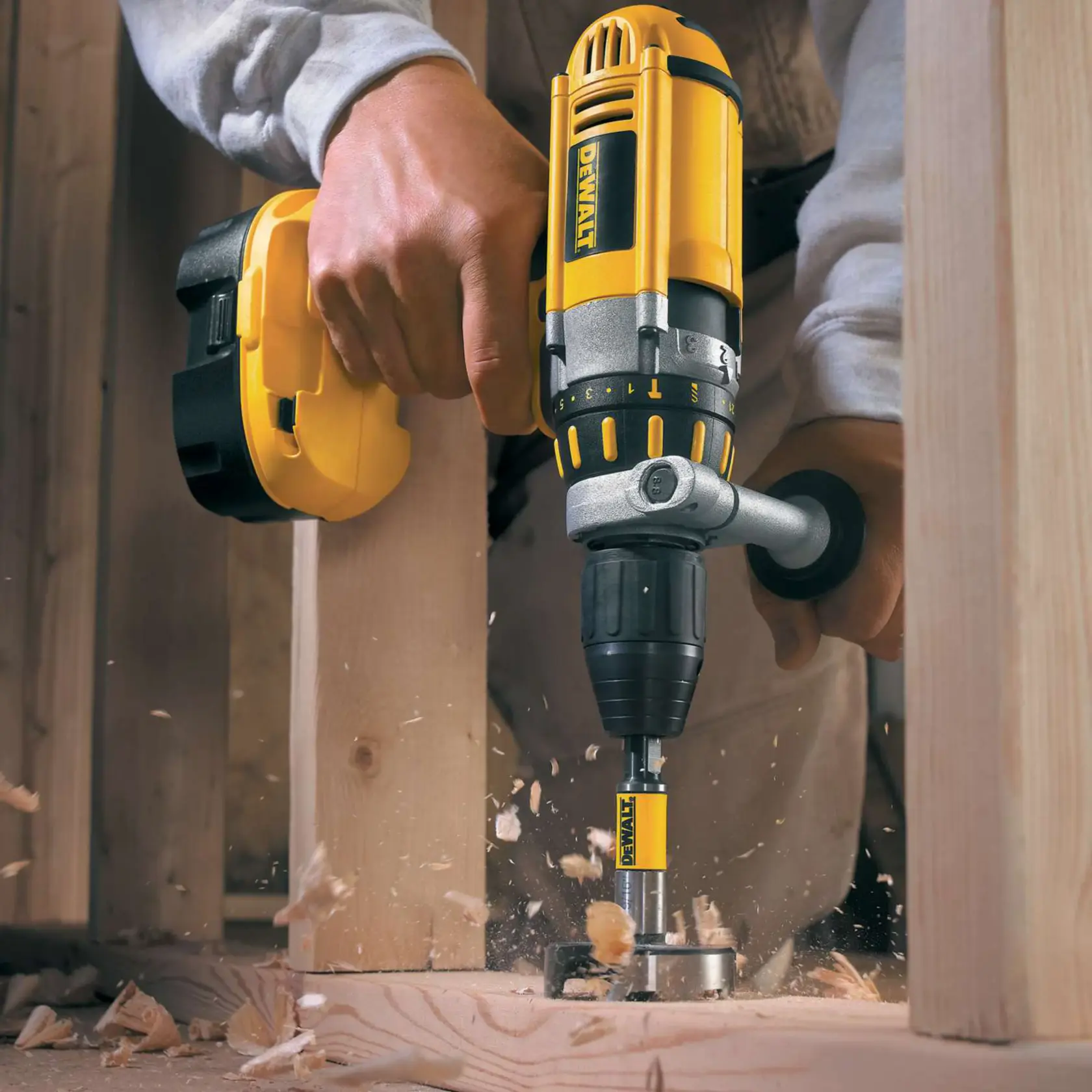 Trapano DEWALT fora una trave di legno, con schegge che volano durante la lavorazione.