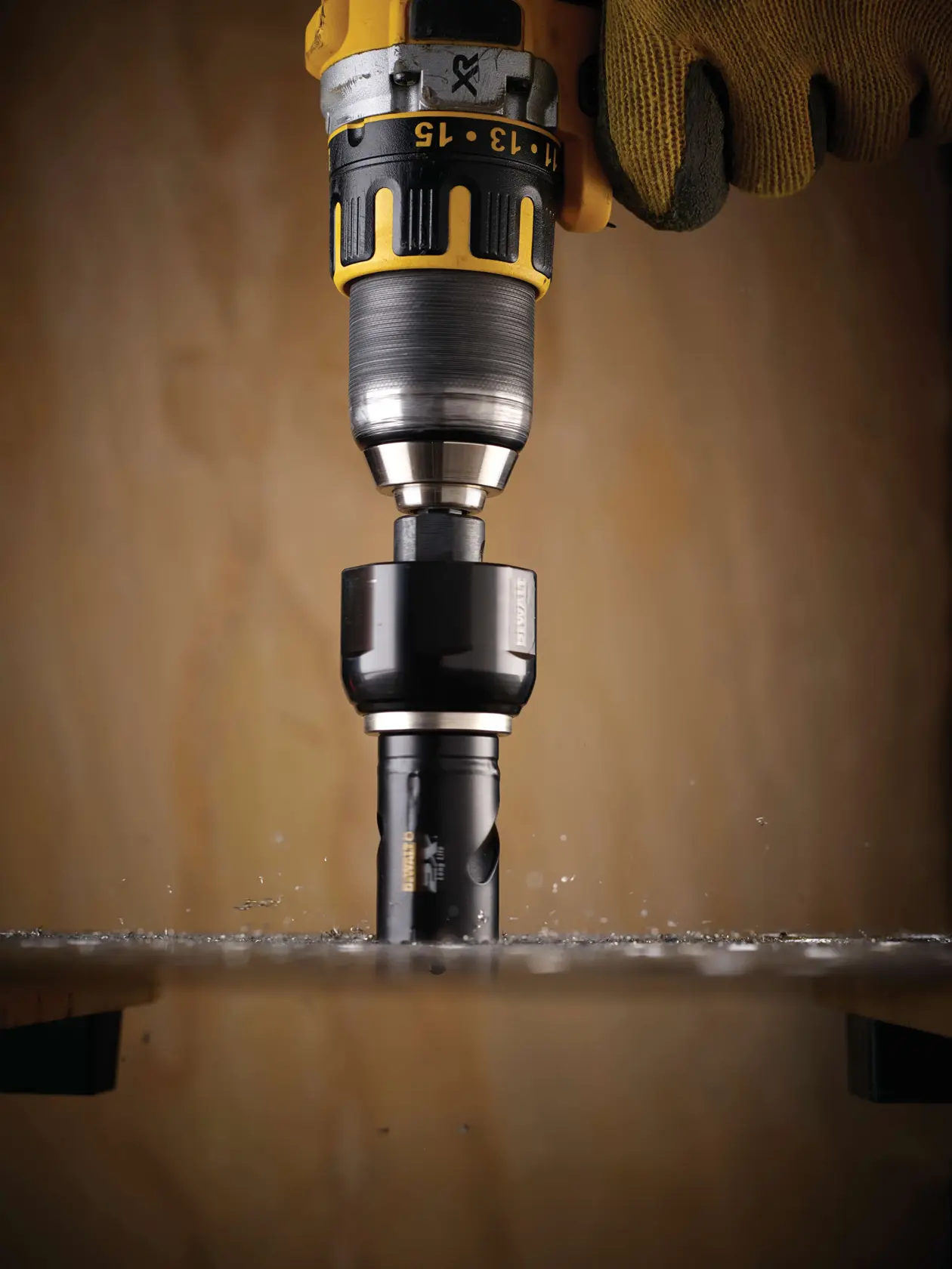 Trapano DEWALT con fresa DT8121L che taglia il legno, manovrato da mano con guanto.