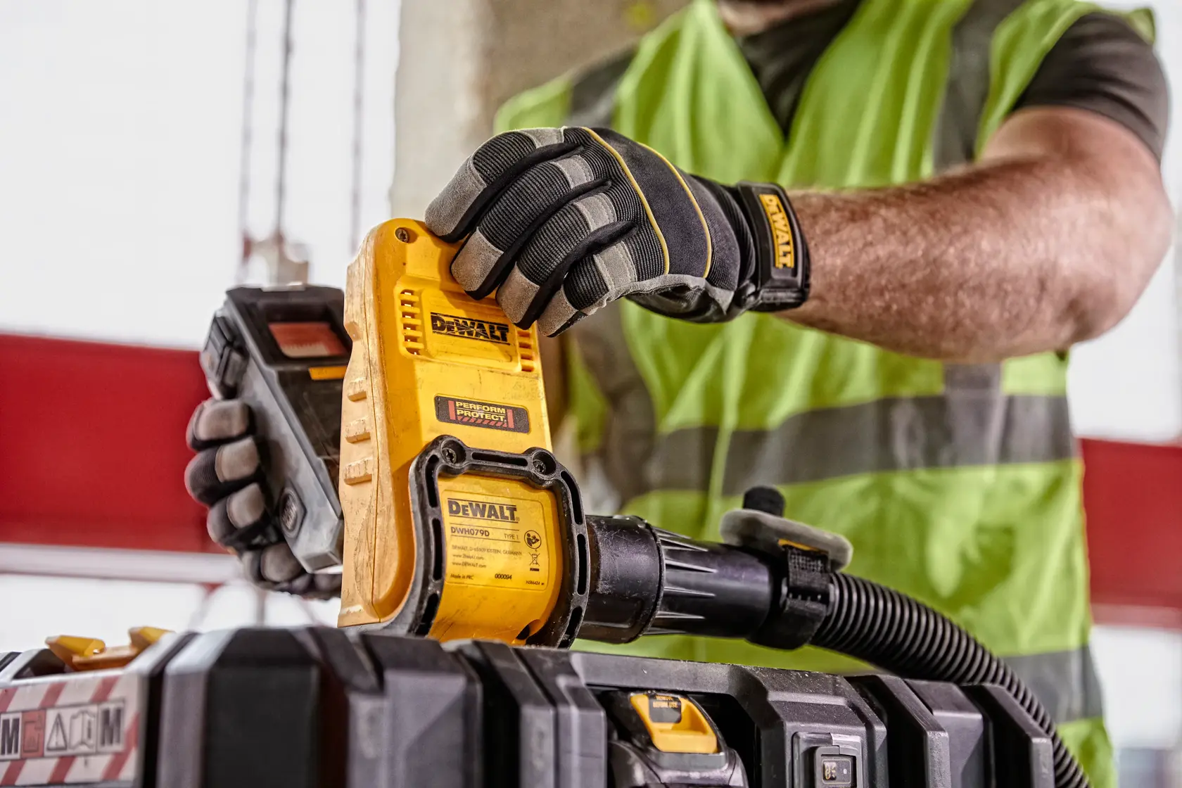 Vue de face d'un évacuateur de boîte à poussière DEWALT DWH079D, un accessoire de photographie avec un corps jaune, des accents noirs et des étiquettes d'avertissement.